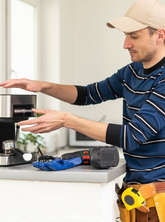 A man in a blue shirt and hat displays a coffee maker, highlighting appliance repair services available in San Jose, CA.